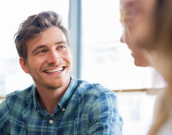 Man in blue shirt smiling at friend