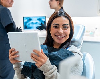 Woman smiling while holding handheld mirror
