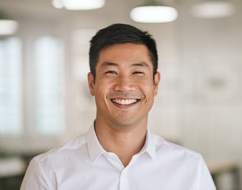 Man in white button up shirt smiling in office