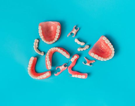Several types of dentures spread out on a blue background