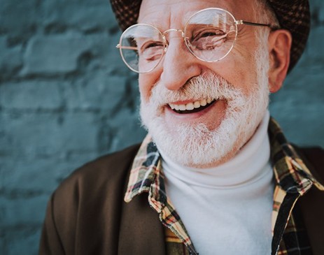 Fashionable man smiling with blue brick background