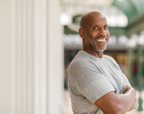 Man in gray shirt smiling outside