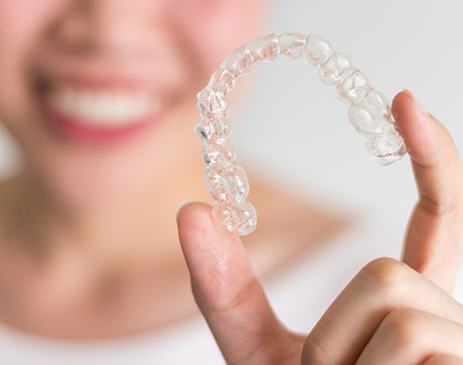 Closeup of patient holding clear aligner