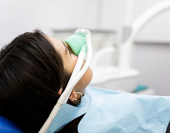 Woman breathing in nitrous oxide in treatment chair