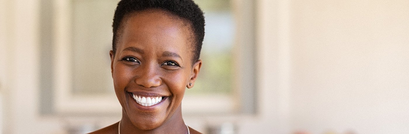 Woman in yellow shirt smiling at home